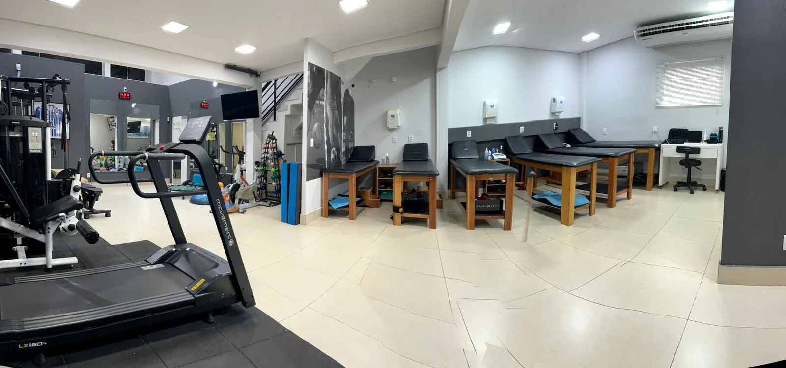 Salão de atendimento da FisioMove em Cuiabá, com aparelhos de exercício e macas de fisioterapia
